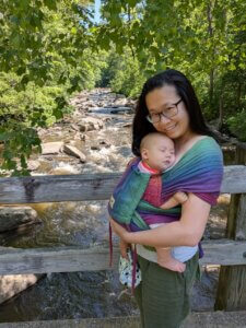 Mom carrying baby in a Girasol Wrapmysol half buckle in the paradise colorway