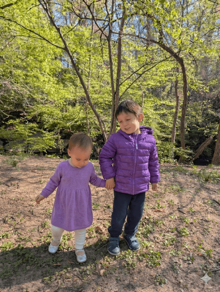 a young boy holding his little sister's hand