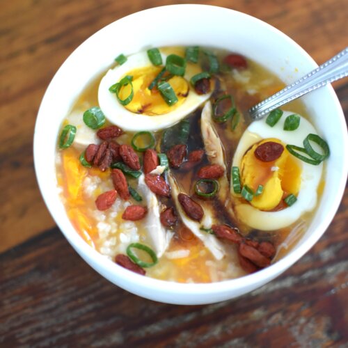 chicken and sweet potato congee in a bowl with egg scallion and goji berries